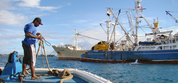 A tender approaches the US flagged fishing vessel Raffaello tied up to a carrier vessel for transshipment of its tuna catch in Port Majuro. Photo: Giff Johnson. US quits fish treaty