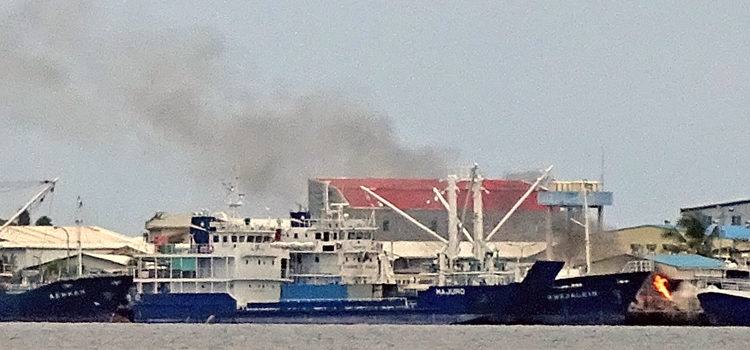 Heavy black smoke poured out from Uliga Dock Friday after an inebriated worker accidentally touched off a fuel fire while lighting a cigarette. Photo: Hilary Hosia. Dock accident badly burns worker