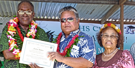 Earlier Watley, left, was honored at the MIHS graduation by Minister Wilbur Heine and Commissioner Evelyn Konou for his 51 years of teaching. Photo: Isaac Marty. Earlie honored at MIHS graduation