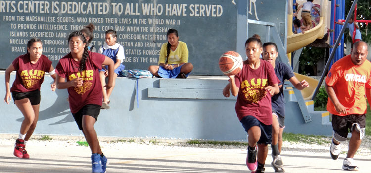 Team Aur players kick off a fast break against Jaluit in 17th BOMI Ralik Ratak Shootout action under the watchful eye of referee and tournament director Rickiano Antibas (right) at SSG Solomon Sam Sports Center at CMI in Majuro. Photo: Hilary Hosia. Ralik Ratak rocks despite rain