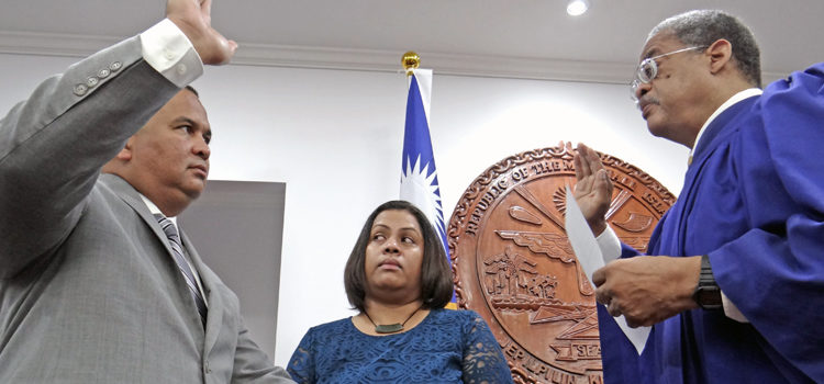Kwajalein Senator David Paul, left, takes the oath as a Cabinet Minister as his wife, Dr. Marie Lanwi-Paul, holds the bible, and High Court Chief Justice Carl Ingram handles administration of the oath. Photo: Hilary Hosia David newest Cabinet appointee
