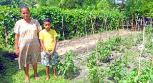 Marilla Capelle with her son Nilo Lolin by their expansive farm in the Iolap area of Laura, Majuro. Photo: Kelly Lorennij.