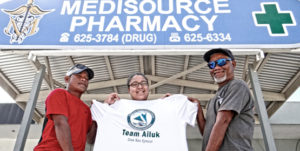 Kwajalein Day canoe race winners Jeffrey Bunglick and Will Alfred joined with canoe co-owner Rosemary Alfred in Majuro for a photo outside the family business. Photo: Hilary Hosia