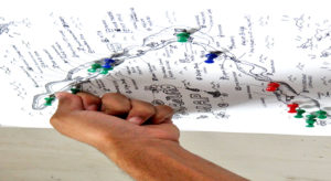 A Journal employee adds another thumbtack onto a chart that shows the location of suicides in Majuro over the past three years.