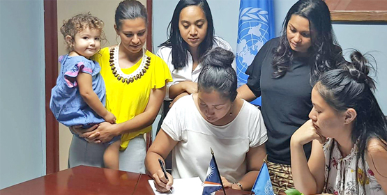 Signing off on the new UNDP grant were, KIO Club President Emma Kabua-Tibon, left, and UNDP Small Grants Manager Yoshiko Yamaguchi-Capelle. Standing from left: Monique Graham with daughter Iia, Shamanda Hanerg, and Francyne Wase-Jacklick. UN backs KIO’s project