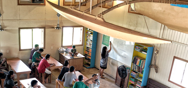 A traditional canoe built by the Waan Aelon in Majel (Canoes of the Marshall Islands) team soars above the WAM classroom, where a group of 25 trainees is engaged in the latest six-month vocational and life skills training. ‘Shooting’ the Majuro scene