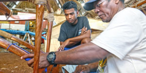Waan Aelon in Majol’s master canoe builder Binton Daniel and a trainee work on an outrigger canoe that will be hung in the lobby of the new Marshall Islands Marine Resources Authority headquarters building that is soon to open. Photo: Hilary Hosia.