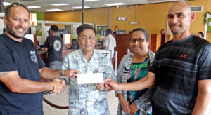 Marshall Islands Basketball Federation President Sherwood Tibon, left, and member at large Robert Pinho, right, accept a check from Bank of Marshall Islands President and CEO Patrick Chen and BOMI Executive Secretary Marilyn Harry for the BOMI 18th Ralik Ratak Shootout Basketball Tournament. BOMI is the major sponsor for the basketball showcase tourney. Photo: Hilary Hosia.