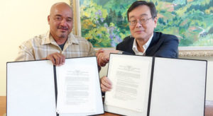 Arno Mayor Bernard Chong Gum and Japan Ambassador Norio Saito show the grant agreement after the signing ceremony last week.