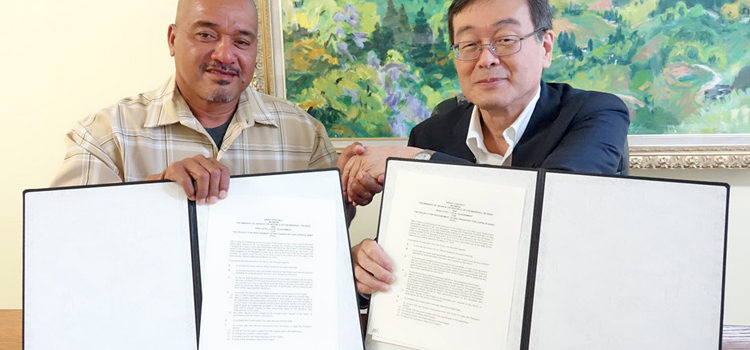 Arno Mayor Bernard Chong Gum and Japan Ambassador Norio Saito show the grant agreement after the signing ceremony last week. Japan backs Arno copra plan