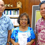 Public School System Commissioner Evelyn Konou holds a copy of Marshallese Reference Grammar that was presented to her and Education Minister Wilbur Heine (right) by Customary Law and Language Commission Chairman Alfred Capelle (left). Photo: Hilary Hosia.