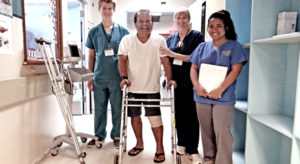 Happy patient Elson Helkena (second from left) wheels his way toward his room accompanied by Canvasback’s Kenyon Johnson, Lela Elloway and Mariza Mendoza. Photo: Hilary Hosia.