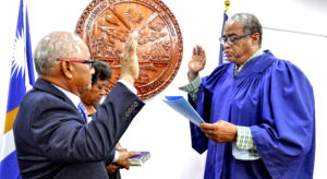Enewetak Senator Jack Ading (left) takes the oath of office as the new Minister of Justice, Immigration and Labor from Chief Justice Carl Ingram as Ading’s wife Luren holds the Bible. Photo: Hilary Hosia.