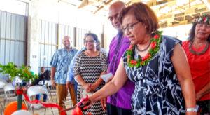 President Hilda Heine cuts the ribbon to the new can and bottle recycling equipment at Majuro Atoll Waste Company’s recycling center as MAWC Manager Jorelik Tibon and other VIPs look on. Photo: Hilary Hosia.