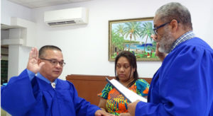 New District Court Presiding Judge Ablos Paul was sworn into his new post last Thursday by Chief Justice Carl Ingram. Holding the Bible is Judge Paul’s wife Helena. Photo: Hilary Hosia.