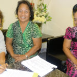 Evelyn Konou, left, signs a letter to Nitijela Speaker Kenneth Kedi as part of delivering a petition that Konou and Biram Stege, center, organize that calls for restoration of postal absentee voting rights. They presented the petition, signed by over 800 people, to Nitijela Clerk Morean Watak Monday this week. Watak put it on Nitijela’s calendar, which sparked discussion at Wednesday’s session. Photo: Hilary Hosia.