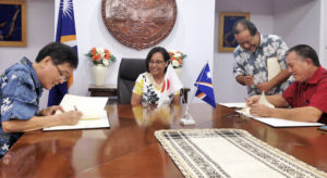 Japan Ambassador Norio Saito, left, and RMI Foreign Minister John Silk, right, sign two grant agreements while President Hilda Heine and Foreign Secretary Bruce Kijiner look on.