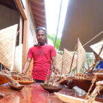 President of the WAM student trainee group Thomas Langidrik is surrounded by canoes built by trainers and trainees in the program as he spoke to visitors at the open house. Photo: Kelly Lorennij.