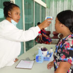 Majuro hospital nurse Gina Anuntak takes the temperature of a person entering Majuro hospital for services recently, one of a number of new practices instituted in the Covid-19 environment. The RMI has no confirmed cases of Covid-19 locally. Photo: Eve Burns.