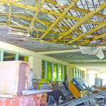 The former RMI capital building’s entryway ceiling has caved in, concrete is peeling off rusting rebar, and debris and left over construction materials are scattered about. Photo: Wilmer Joel.