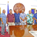President David Kabua center, with RRE representative Norbert Reimers (to his right) and AKIA Cafe representative Ace Doulatram (to his left) at the July 10 check presentation. From left: RMI Economic Impact Assessment Committee Co-Chair Reginald White, Ministers Casten Nemra and Sandy Alfred, Reimers, Kabua, Doulatram, Ministers Chris Loeak and Bruce Bilimon, and Chief Secretary Kino Kabua. Photo: Eve Burns.