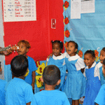 Bilingual education unit (BEU) teaching instructor Pruter Karben gets NDES kindergarteners signing as part of a new educational initiative of the ‬Bilingual Education Unit, which was established by the Customary Law and Language Commission, Public School System, and the College of the Marshall Islands‪. Photo: Jora Jora.‬