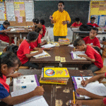 Student attendance in public schools increases on the three days per week the government schools provide lunch. Pictured is Rita Elementary School teacher Mariano Abin working with his class. Photo: Asian Development Bank.