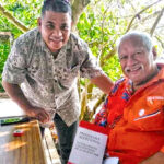 Red Cross Secretary General Ainrik George presents Kwajalein Nitijela Member and Iroojlaplap Michael Kabua a copy of the Geneva Convention Protocols. Photo: Nathan Nathan.