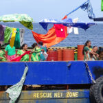 The Ribuuk Meto made its first voyage to Ebeye earlier this month and was decked out with materials and t-shirts, as dancing ladies show the island welcome spirit. Photo: Eve Burns.