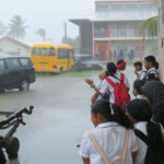 Marshall Islands High School students take cover from heavy rains that hit the capital atoll in early February. Rainfall in Majuro is not a good indicator of rain levels in the northern atolls. Photo: Wilmer Joel