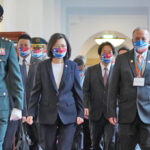 Taiwan President Tsai Ing-Wen and Marshall Islands President David Kabua, decked out in Marshall Islands-Taiwan flag motif face masks, head into the Presidential Office in Taipei.