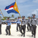 A Majuro Atoll Local Government police honor guard leads a Majuro Day parade into the newly created landfill area in Jenrok that will soon host an Olympic quality track and field, and a baseball field. Photo: Wilmer Joel.
