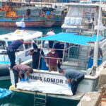 Ministry of Health and Human Services employees prepare to remove the body fished out of the lagoon after it was transported by Sea Patrol’s Lomor II vessel to the MIMRA dock and the waiting ambulance. Photo: Hilary Hosia.