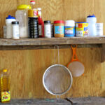 With no cabinet in her kitchen, Demon Town residents Tita Jorlang makes use of a small shelf attached to her wall and a two-by-four that is part of the house construction to store food and household items. Photo: Wilmer Joel.