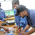 JICA and MEC engineers perform maintenance exercises during a training program last week. Photo: Eve Burns.