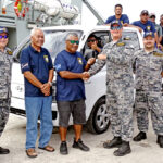 Lt. Commander Lachlan Sommerville shakes hands with Lomor Captain Dennis Jibas as part of handing over the vehicle at the back as top Australia, RMI and Sea Patrol officials join in. Photo: Hilary Hosia.