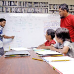 Instructors Jensen Rufus (left) and Jonathan Laik explained how punctuation is used in Marshallese language to a group of upcoming fourth and fifth grade students from Assumption Elementary and Majuro Cooperative School. Photo: Hilary Hosia.