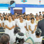 The Rita Protestant Church youth group sang during the opening of this year’s youth convention that is now in progress. They are led by Rev. Jeledrik Binejal, back to camera in suit coat. Photo: Goodwind Silk.