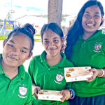 Life Skills Academy students Jomiana Paul, Karmine Peter and Jennyrose Joram shared smiles following their lunch break outside the school at the PSS parking lot Tuesday. According to the girls, they are thrilled to have lunch back on their school agenda. They said they used to prepare lunch from their homes during the weeks PSS was unable to provide food. Photo: Hilary Hosia.