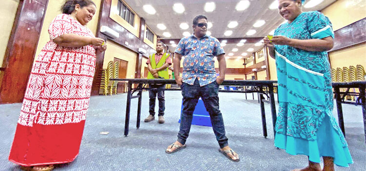 Sisters of Likiep candidates Tommy Kijiner, Jr. and Wallace Peter — Theresia Kijiner, left, and Tilta Peter — check their lots under the watchful eyes of Chief Electoral Officer Ben Kiluwe (at back) and Electoral official Bertnie Philippo at the ICC tabulation headquarters December 20. Photo: Hilary Hosia. Likiep tie: Wallace wins drawing