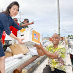 US Department of State Deputy Assistant Secretary for East Asian and Pacific Affairs Jung Pak passes a box of Arno-bound relief supplies to National Disaster Management Office Director Isidore Robert. Photo: United States Department of State.