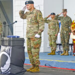 The remains of a fallen US service member recently discovered in the Marshall Islands was front and center at the Richardson Theater last Friday during commemoration ceremonies of the 80th anniversary of Operation Flintlock. Saluting by flag draped container with the remains is Army Command Sgt. Major Ernest Miller. Kwajalein Nitijela Member Kitlang Kabua, at back right, joined with other Army officers for the official ceremony. Photo: Hilary Hosia.