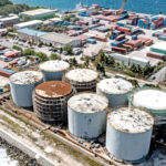 A drone view of the Marshalls Energy Company’s six million gallon fuel storage facility with renovations underway: A newly installed seawall protects the facility and scaffolding is visible around the three tanks that are currently under renovation. Photo: Jeremy Farrington.