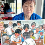 Setsuko Shimomoto, daughter of one of thousands of Japanese fishermen exposed to Bravo hydrogen bomb test fallout in 1954, shows a painting of Japanese high school students interviewing some of the fishermen. She was in Majuro for the 70th anniversary of the Bravo test. Photo: Giff Johnson.