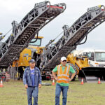 Pacific International Project Manager Bobby Muller, right, and Billy Paguiligan in front of some of the recently imported paving equipment.