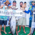 Team Hangloose skipper Larry Hernandez, III, third from right, came from behind last weekend to win the coveted President’s Cup for the first time, defeating 10-time Cup winner Captain Ronnie Reimers. In addition to winning the Atjang Memorial Trophy for good sportsmanship, Larry’s team won the tuna division with this 75 pound dogtooth tuna. From left at the MBC weigh-in: Francis deBrum, Travis Clark, Larry Hernandez Jr., Larry Hernandez III holding daughter Leipuakenikeni Hernandez, Stephen Clark Jr. and Miss Billfish Carnie Reimers. Photo: Chewy Lin.