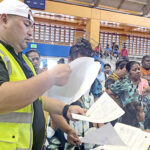 MISSA Administrator Bryan Edejer, who is overseeing the registration blitz for the new Enra universal basic income program, was spotted at the ECC gym Monday checking documents of applicants. Photo: Hilary Hosia.