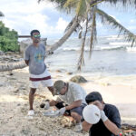CMI Instructor Kendal Romany, right, with his students in their class on the beach. Photo: Wilmer Joel.