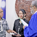 New Cabinet Minister Gerald Zackios, left, takes the oath of office administered by High Court Chief Justice Carl Ingram, as his daughter Katt Chong Gum holds the Bible during the oath ceremony. Photo: Hilary Hosia.