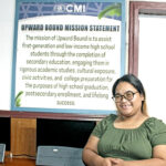 Upward Bound Director Pam Kaious, who took up the post in May, with the program’s mission statement at the back. Photo: Wilmer Joel.